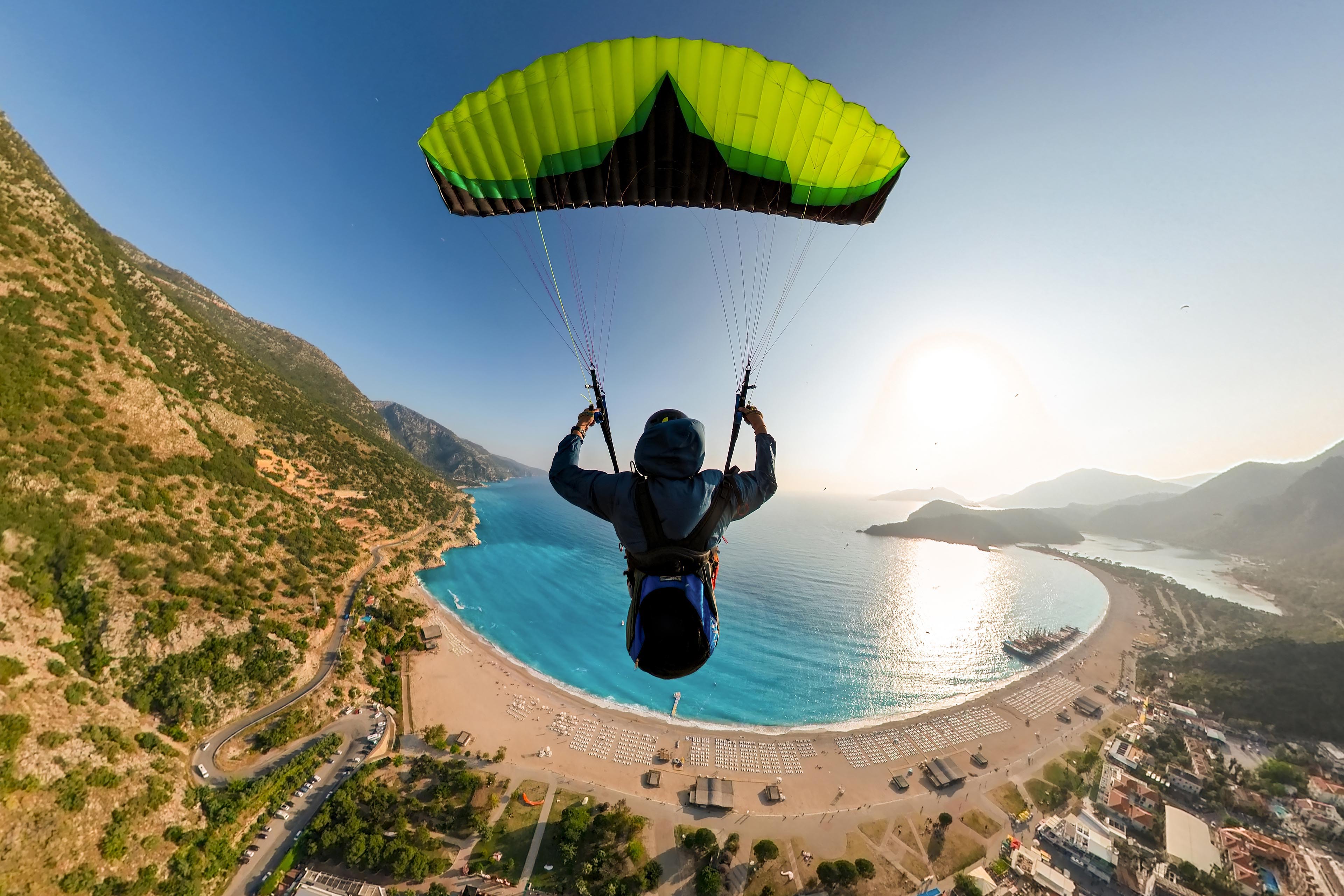 Extreme paraglider pilot flying over the beach Extreme paraglider pilot flying over the beach
