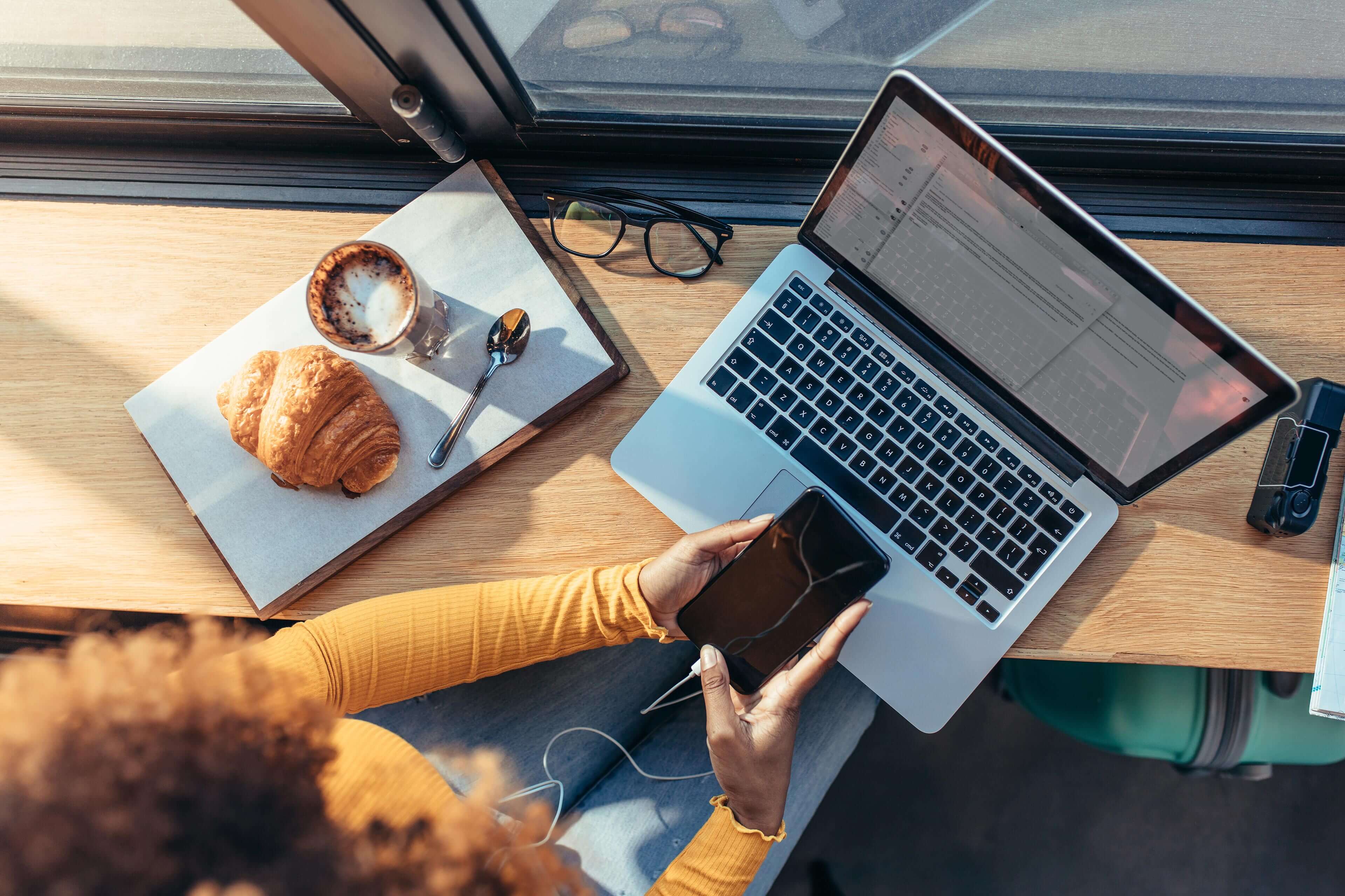 Woman using phone and laptop