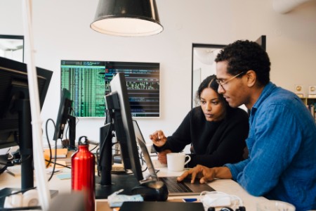 male and female working over laptop