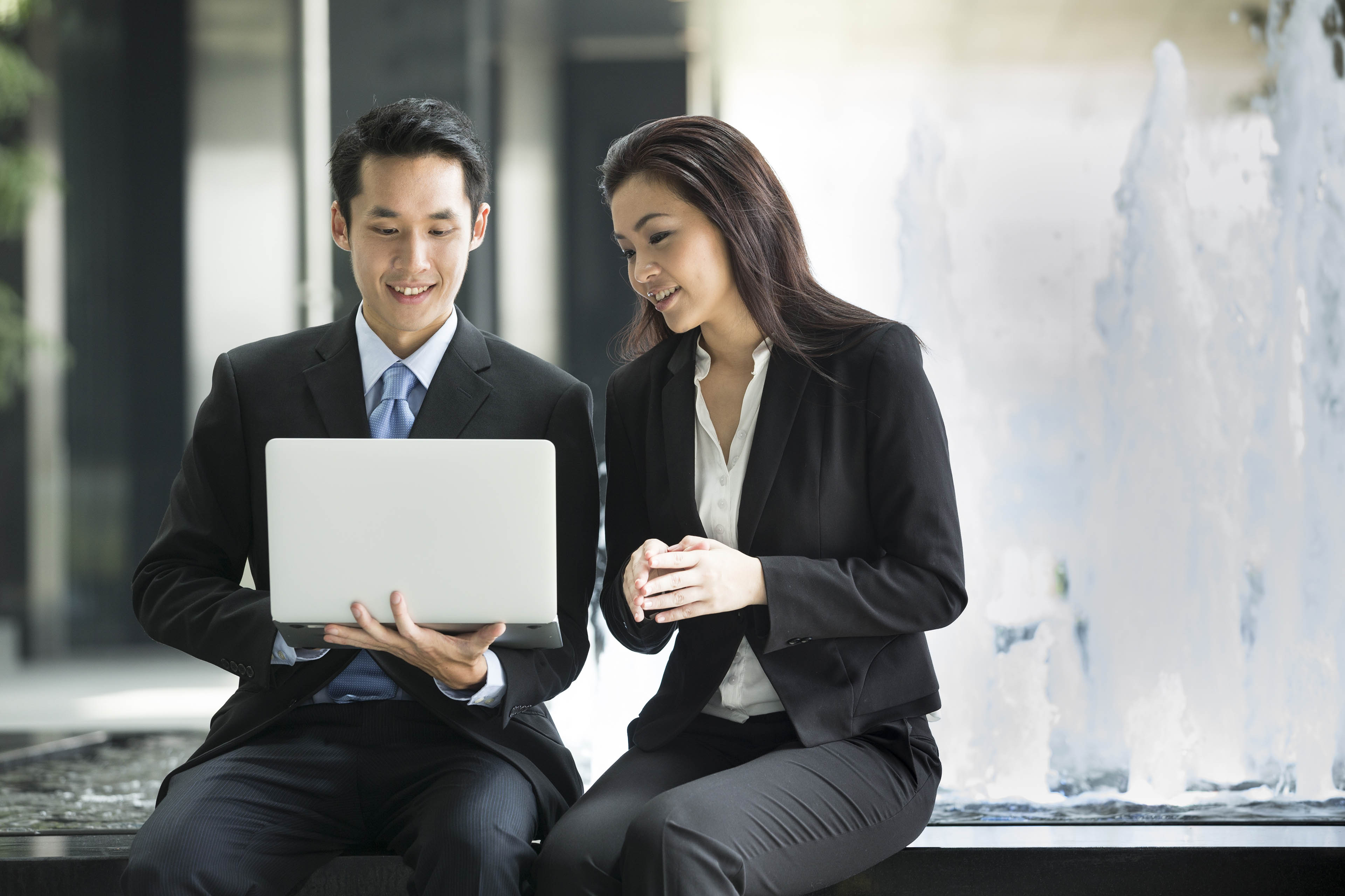 Two professionals meeting in front of industrial equipment image