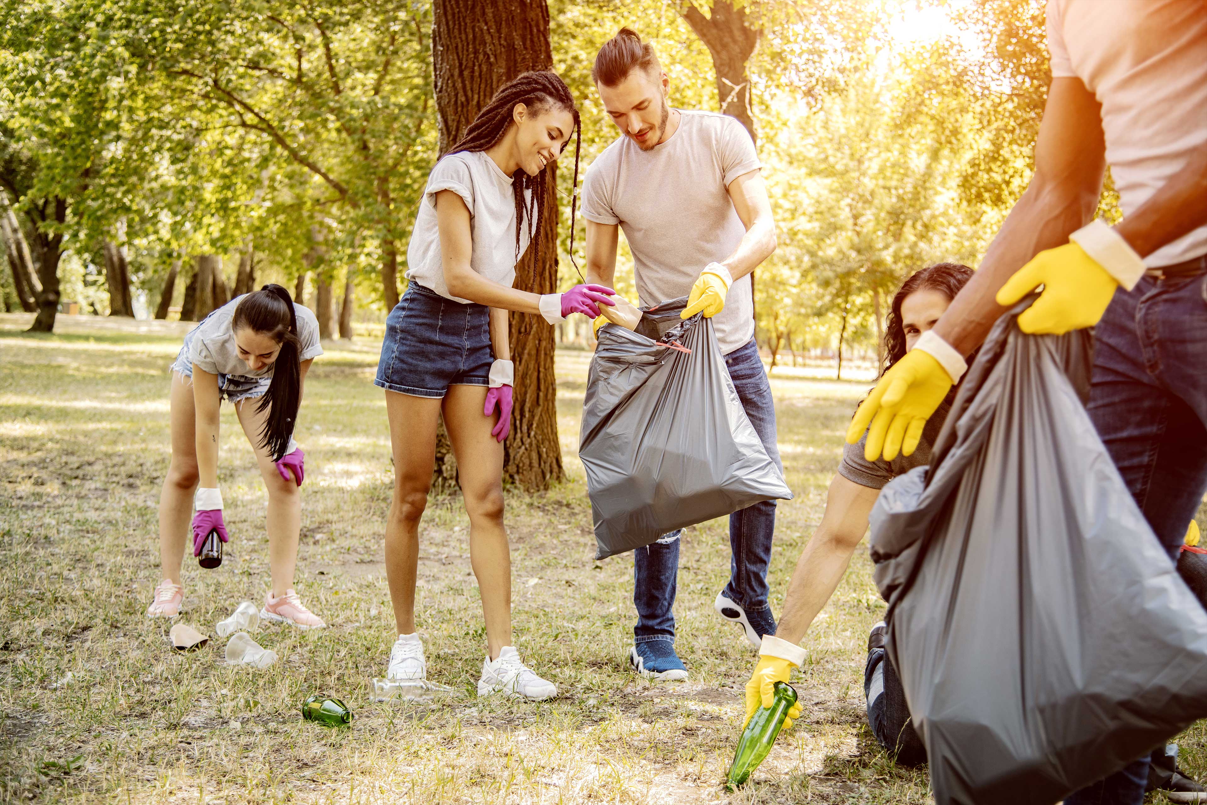 People picking up litter with trash bags People picking up litter with trash bags
