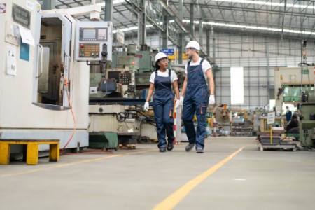 Two engineers chat as they walk through an automated factory
