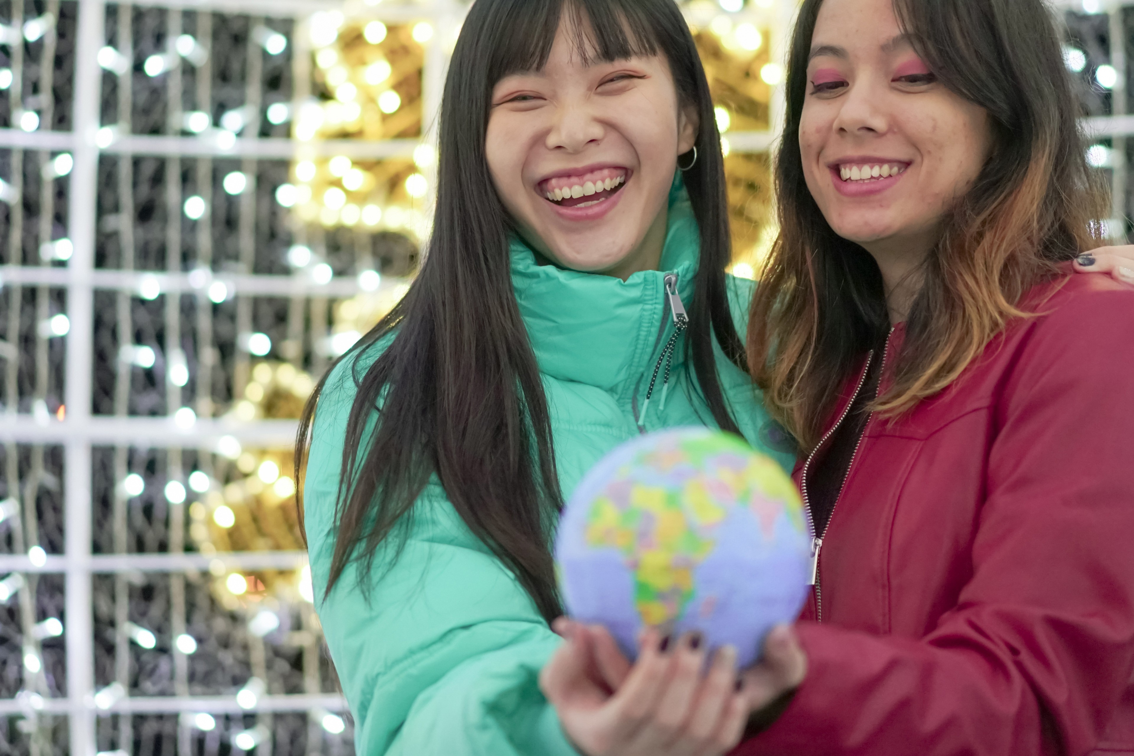 Two women holding model globe Two women holding model globe