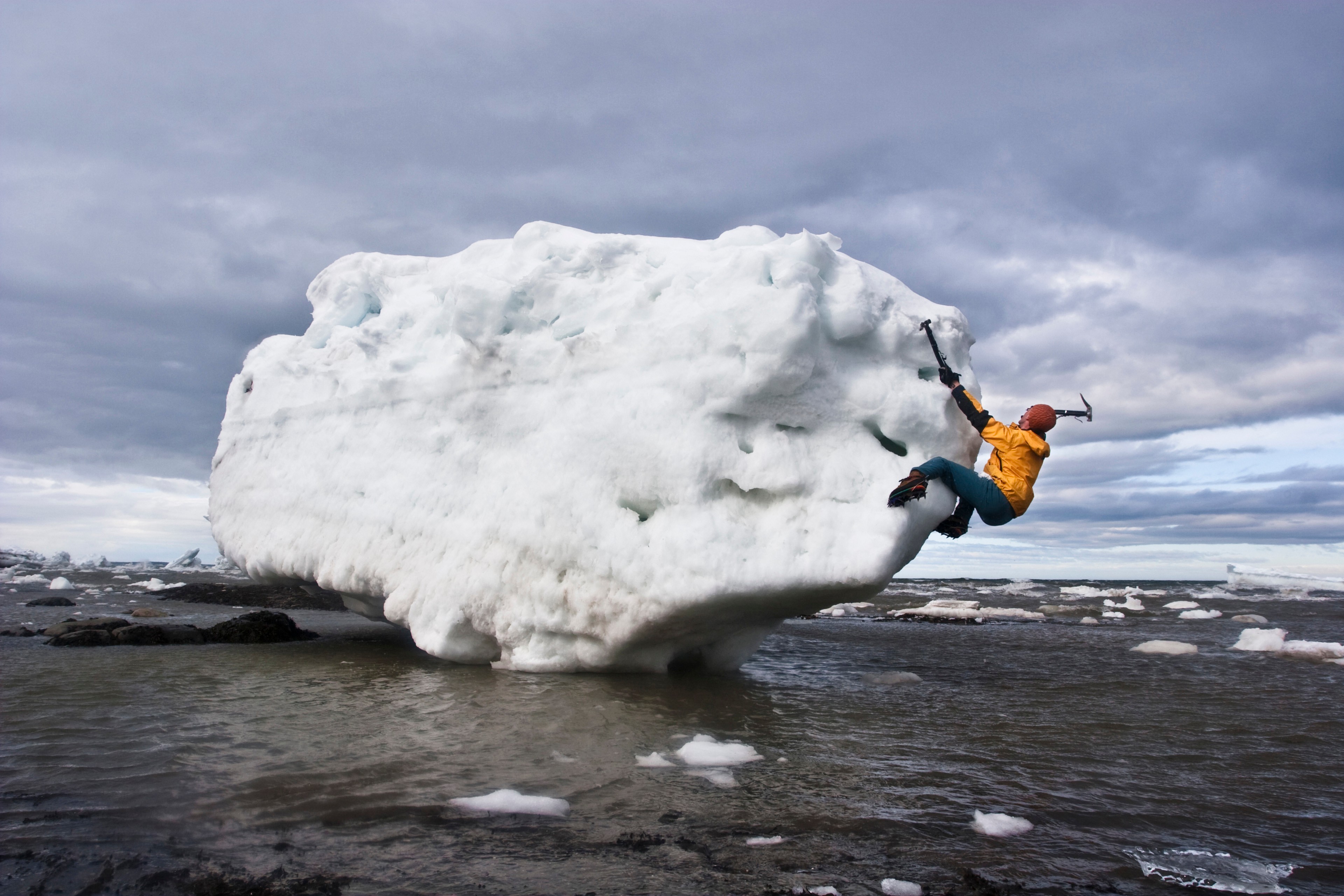 Person ice bouldering on iceberg Person ice bouldering on iceberg