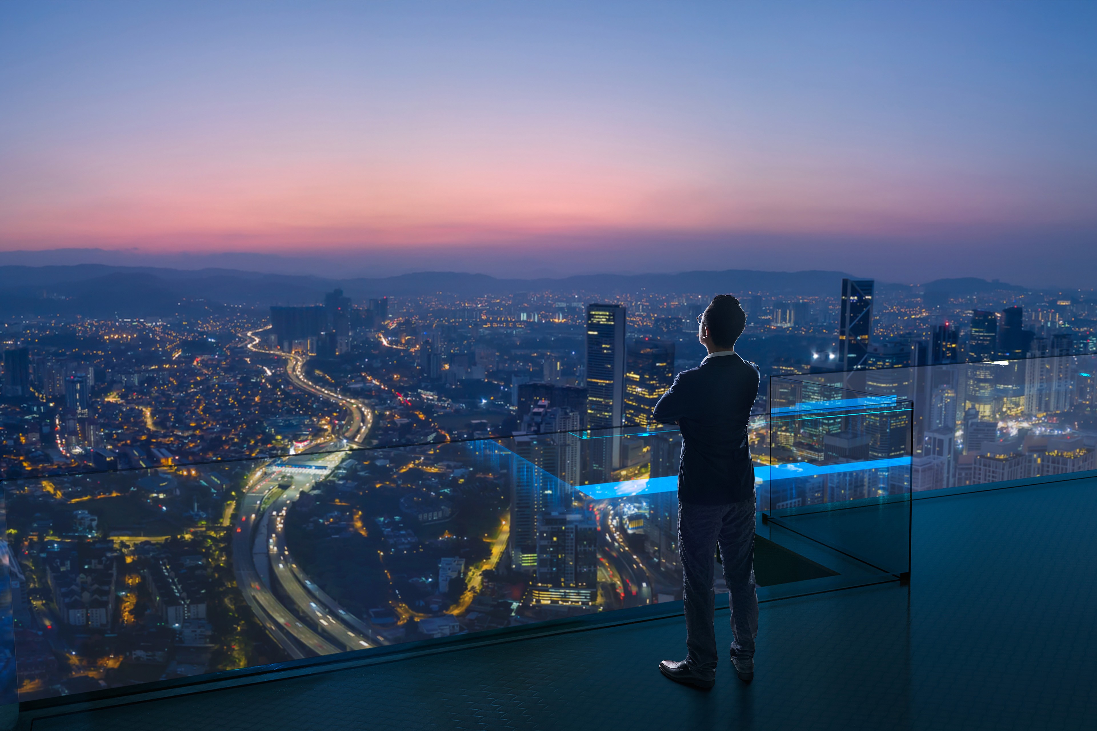 Business person on balcony overlooking city